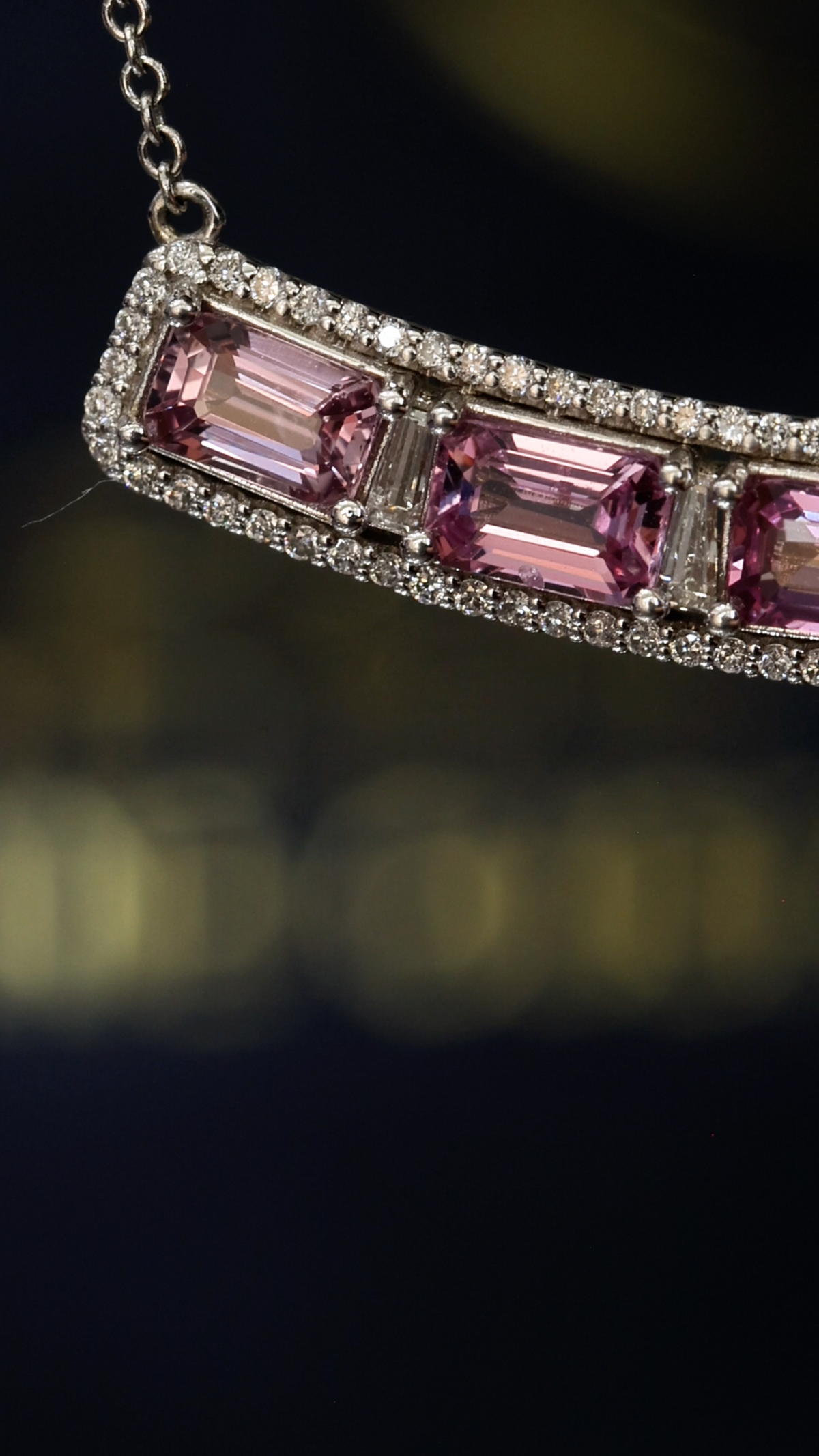 14K white gold curved pink sapphire bar necklace with 2.9 carat emerald cut sapphires and 0.5 carat diamond halo setting