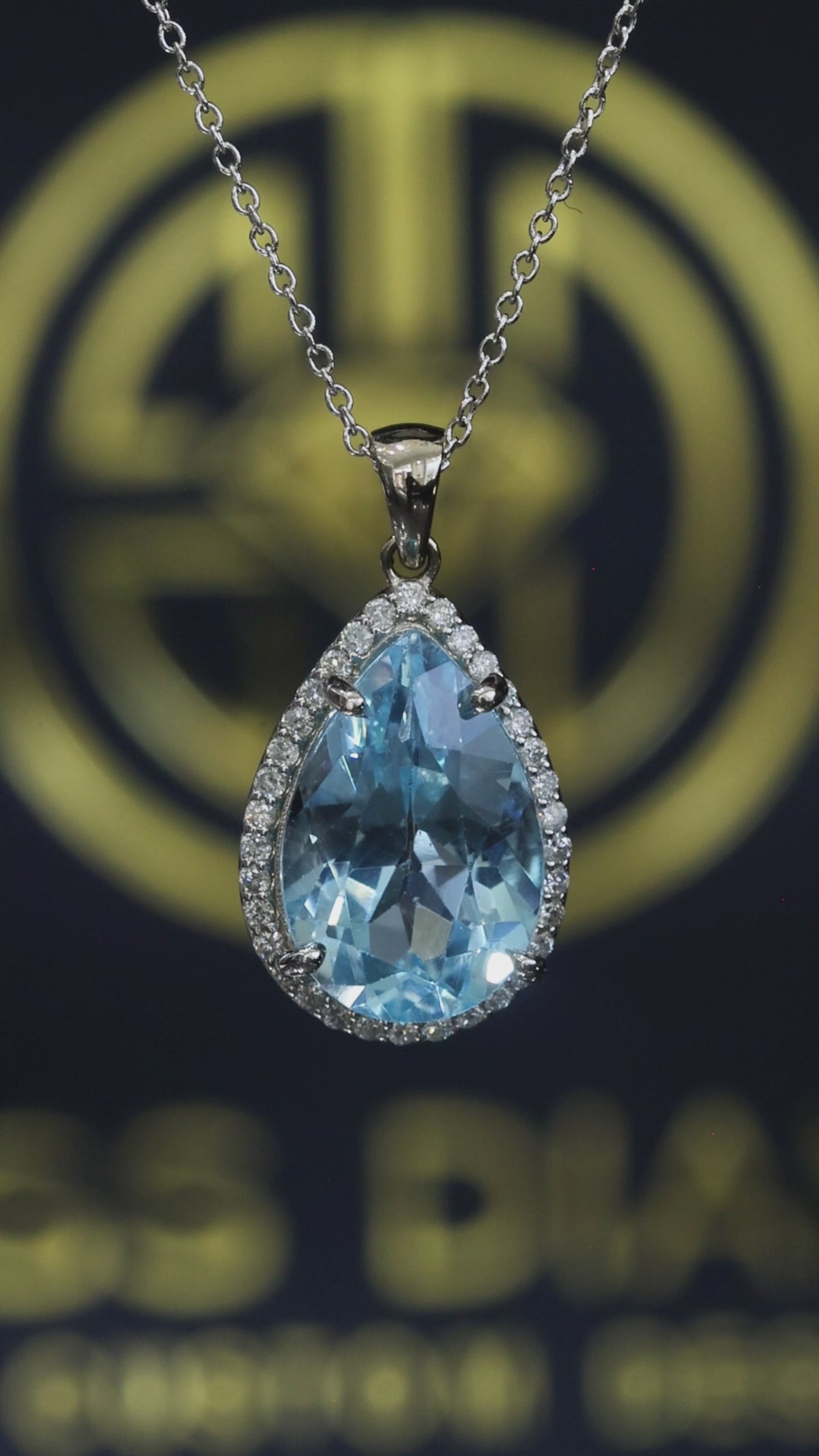 Pear shape blue topaz halo pendant in 14K white gold with 0.27 carat G-H SI diamond accents Houston jewelry store Endless Diamonds
