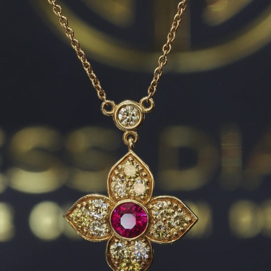 14K yellow gold ruby floral pendant with 0.80 carat fancy yellow diamonds and bezel-set ruby center with diamond station chain