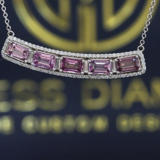 14K white gold curved pink sapphire bar necklace with 2.9 carat emerald cut sapphires and 0.5 carat diamond halo setting